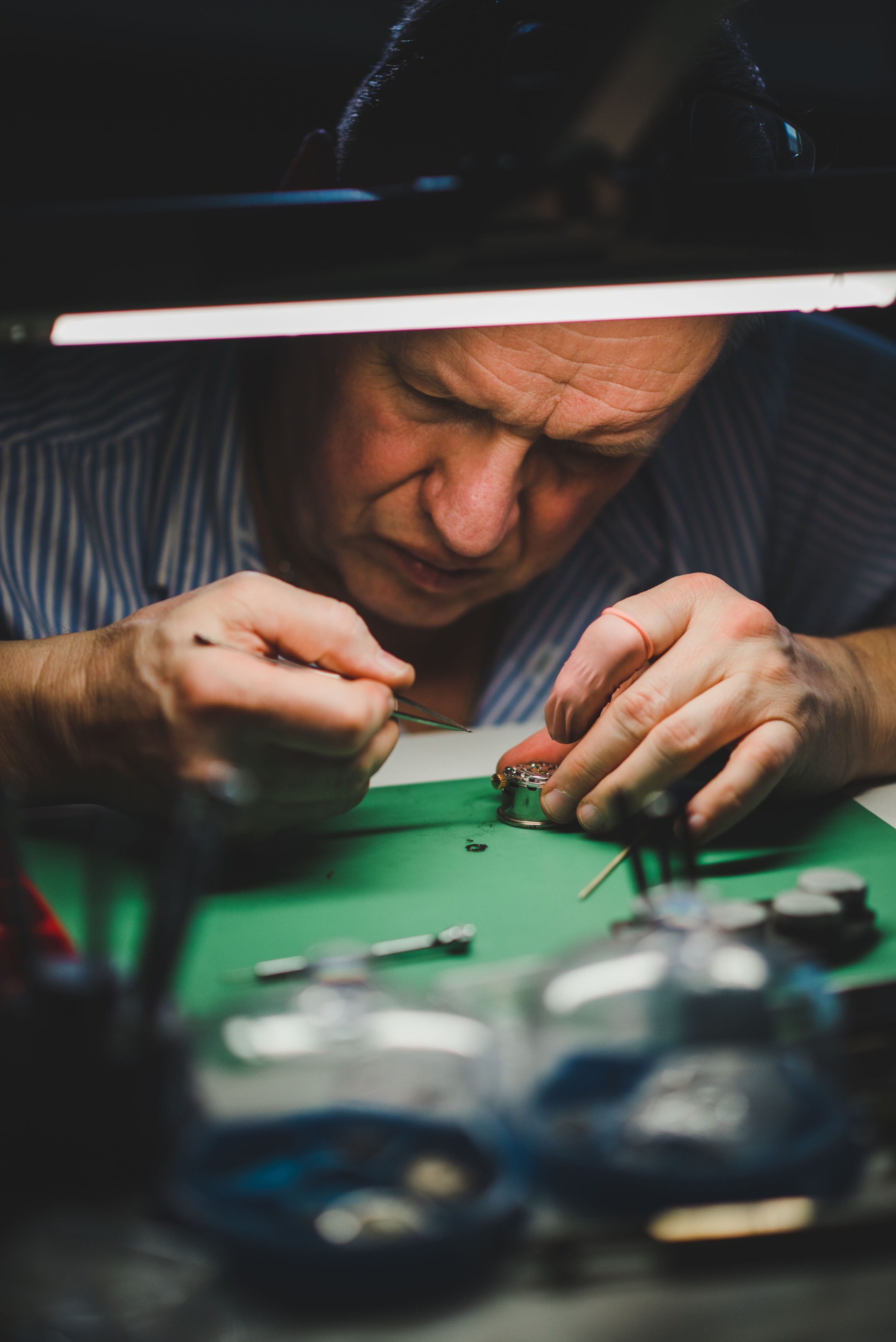 Watchmaker servicing a watch movement at the workbench