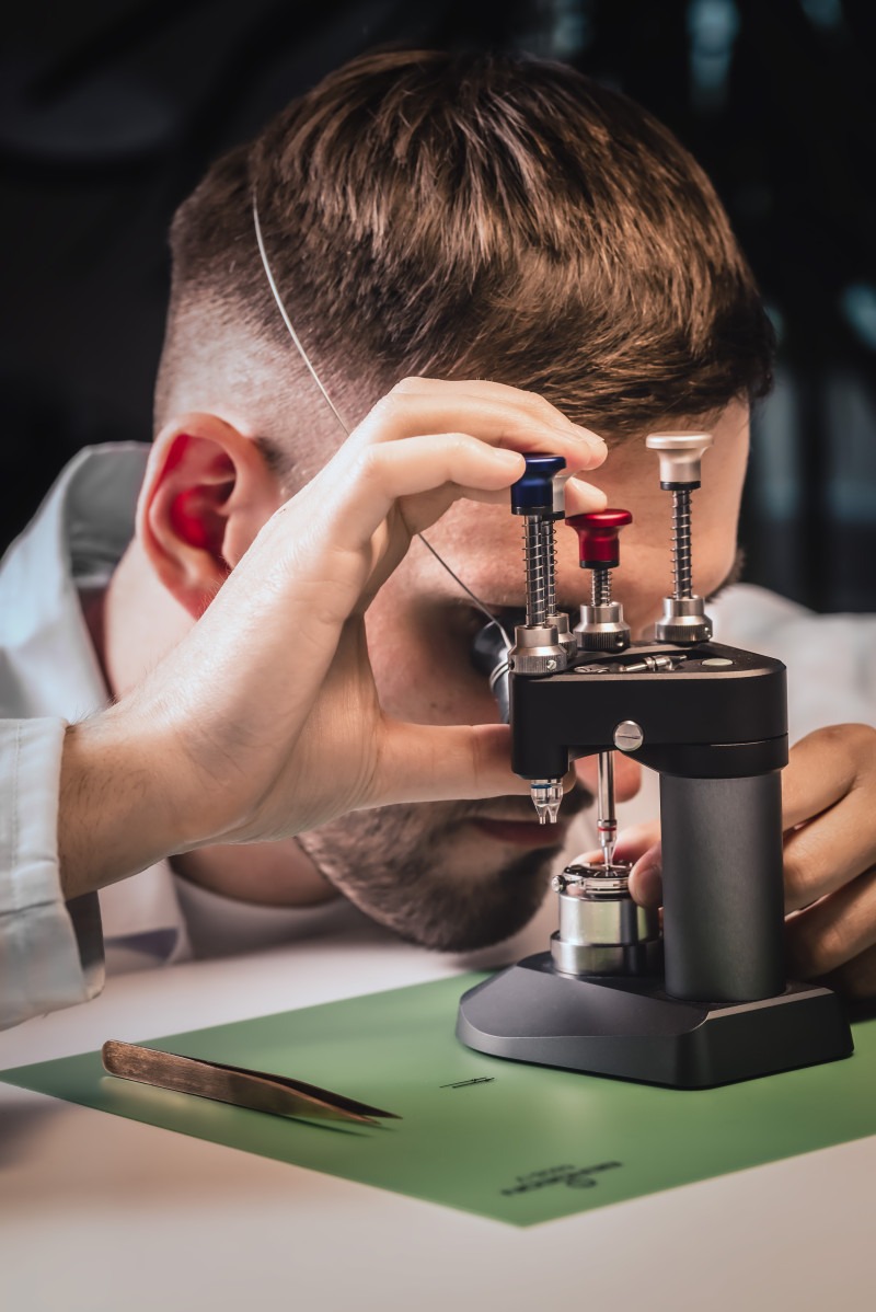 Watchmaker using a microscope for precision work